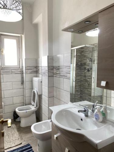 a white bathroom with a sink and a toilet at B&B Royal Prato in Prato