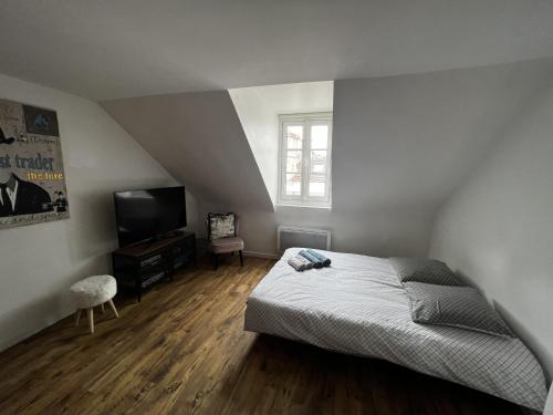 une chambre avec un lit et une télévision à écran plat dans l'établissement Sweet Abreuvoir, à Saint-Germain-en-Laye