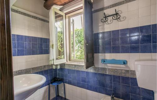 a blue tiled bathroom with a sink and a window at Cozy Home In Arenella With Outdoor Swimming Pool in Arenella