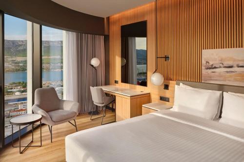 um quarto de hotel com uma cama, uma secretária e cadeiras em AC Hotel by Marriott Split em Split