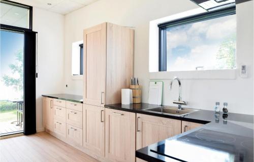 eine Küche mit Holzschränken und einem Waschbecken in der Unterkunft Lovely Home In Brkop With Wifi in Børkop