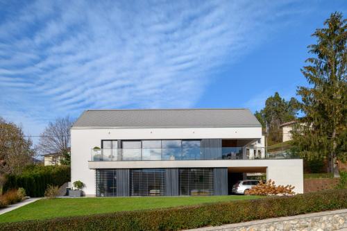 een wit huis met een grijs dak bij Studio ELITE in Bled
