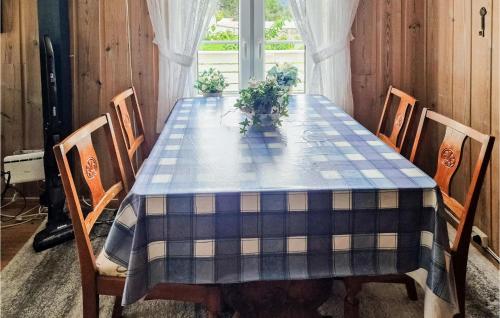 mesa de comedor con mantel a cuadros azules en Cozy Home In Fjra With Kitchen, en Fjæra