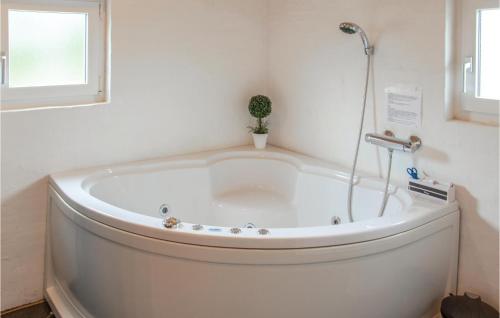 uma banheira branca num quarto com uma janela em Stunning Home In Glesborg With 4 Bedrooms, Sauna And Wifi em Fjellerup Strand