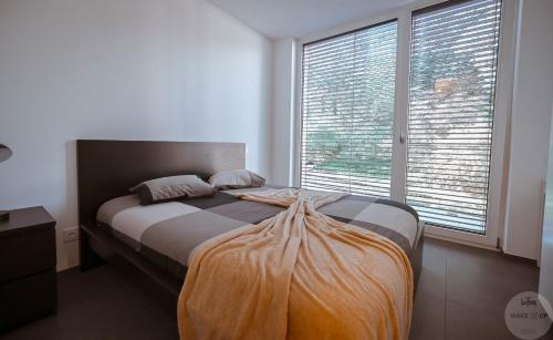 uma cama num quarto com uma grande janela em WakeUp Lux-City 