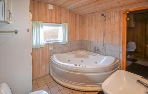 Fjellerup StrandにあるAwesome Home In Glesborg With 4 Bedrooms, Sauna And Wifiの窓付きのバスルーム(大きな白いバスタブ付)