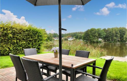 una mesa de madera con sillas y una sombrilla en Lovely Home In Vlagtwedde With Kitchen en Vlagtwedde