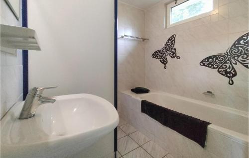 een witte badkamer met een wastafel en een bad bij Lovely Home In Vlagtwedde With Kitchen in Vlagtwedde