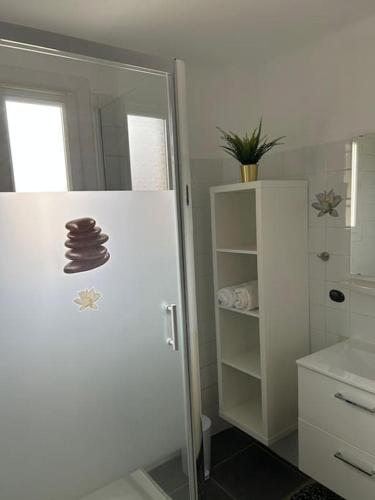 La salle de bains est pourvue d'un réfrigérateur blanc et d'un miroir. dans l'établissement Appartement à deux pas du tram, à Avignon