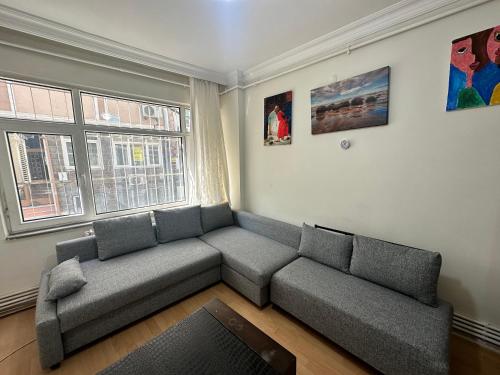 uma sala de estar com um sofá e uma janela em 1+1 Flat in Fatih Aksaray em Istambul