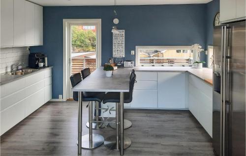 a kitchen with blue walls and a table with chairs at Nice Home In Sandefjord With Wifi in Sandefjord
