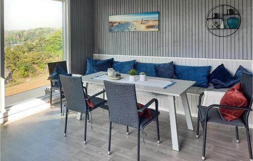 a dining room with a table and a blue couch at Nice Home In Sandefjord With Wifi in Sandefjord
