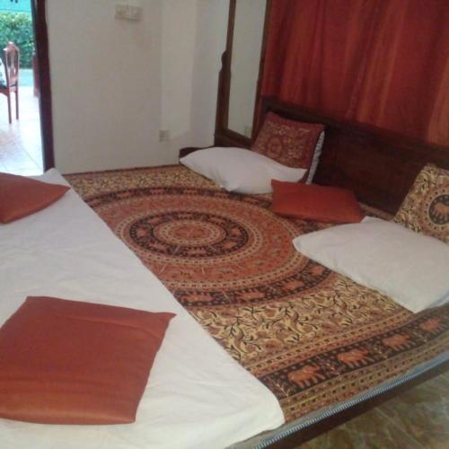 a room with two beds and a rug at Grace Villa Bentota in Bentota