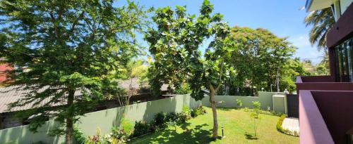 een tuin met bomen en een hek bij Jes Villa in Panadura