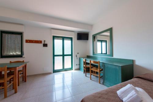 a room with a bed and a table and a mirror at Villaggio Alkantara in Giardini Naxos