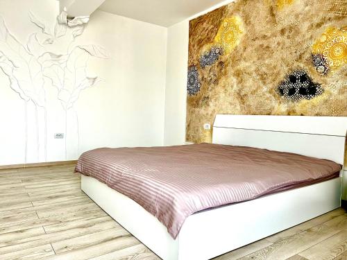 Apartament Dem Rădulescu Lidl في رمينكو فيلتشا: غرفة نوم بسرير مع لوحة على الحائط