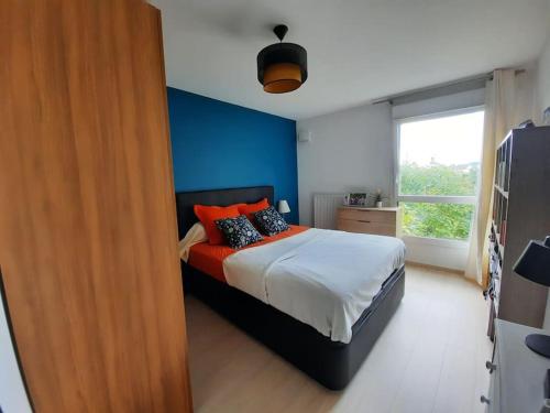 - une chambre avec un lit aux murs orange et bleu dans l'établissement F3 neuf tout équipé de 62m2 centre ville, à Annecy