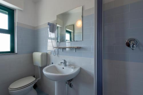 a bathroom with a sink and a toilet and a mirror at Villaggio Alkantara in Giardini Naxos