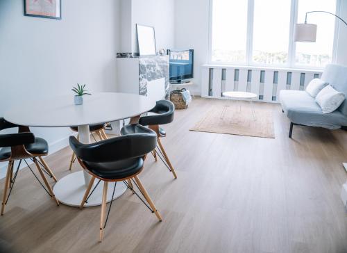 a living room with a table and chairs and a couch at Appartement vlakbij Antwerpen centrum! in Antwerp