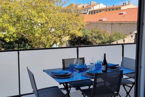 une table bleue et des chaises sur un balcon dans l'établissement Appartement Neuf, Superbe Déco, 2 chambres, Centre historique, 2 Parkings Privés, à Sète