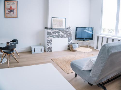a living room with a couch and a tv at Appartement vlakbij Antwerpen centrum! in Antwerp