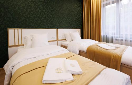 a hotel room with two beds with towels on them at Dream Hotel in Haghpat
