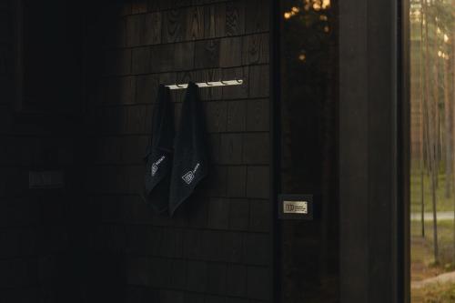 two black umbrellas hanging on a brick wall at ÖÖD Hötels Lohusalu LEIDA & ENNO in Laulasmaa