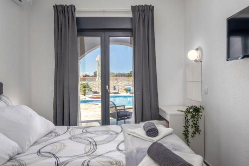 - une chambre avec un lit et une vue sur la piscine dans l'établissement Rustic Luxury Villas Dalma & Dalmata, à Murvica