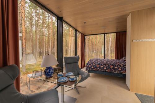 a bedroom with a bed and a table and chairs at ÖÖD Hötels Lohusalu LEIDA & ENNO in Laulasmaa