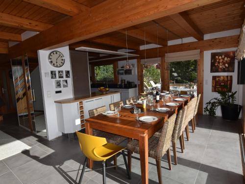 une salle à manger avec une grande table et des chaises jaunes dans l'établissement Chalet spacieux, skis aux pieds avec sauna, jacuzzi et salle de sport, proche centre et pistes - FR-1-467-68, au Grand-Bornand