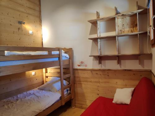 a bedroom with two bunk beds and a red couch at Appartement Saint-François-Longchamp, 2 pièces, 6 personnes - FR-1-635-85 in Saint-François-Longchamp