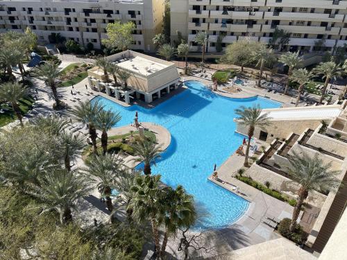 - une vue sur la piscine bordée de palmiers et de bâtiments dans l'établissement Enticing Huge Unit at Cancun Resort Strip Las Vegas, à Las Vegas