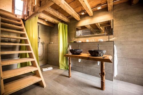 - une salle de bains avec deux lavabos sur une table en bois dans l'établissement La Pinte du Vieux Manoir, à Morat