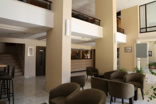 a lobby with chairs and tables in a building at Rıdvan Hotel in Cesme