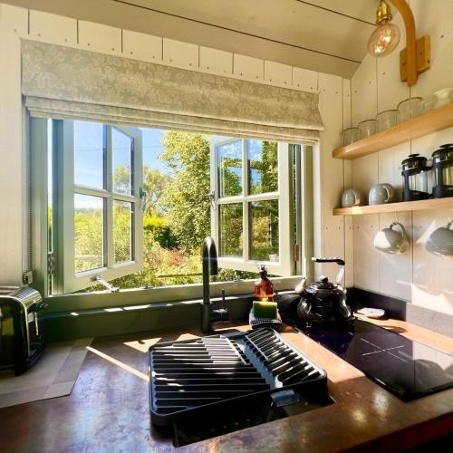 a kitchen with a large window and a counter top at Cocklebury Farm in Pewsey