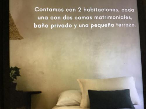 um quarto com uma cama com uma citação na parede em Casaluna em Malinalco