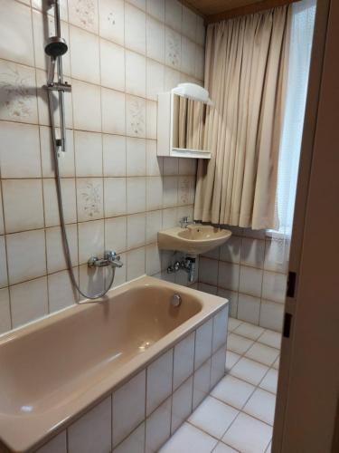 y baño con bañera y lavamanos. en Mariazell Salza Haus, en Gusswerk