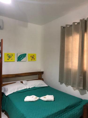 a bedroom with a bed with two white towels on it at Chalé em Barreirinhas - Porto dos Lençóis in Barreirinhas