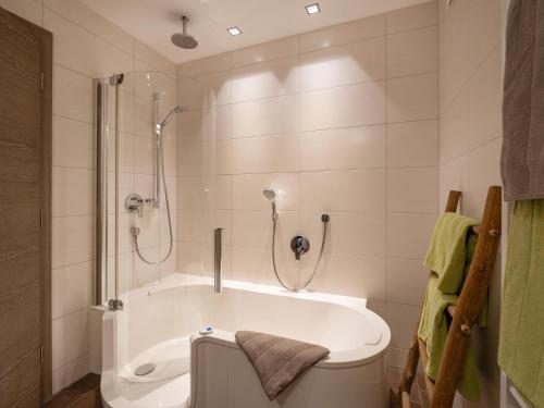 a bathroom with a bath tub and a shower at Alpensuiten in Ellmau
