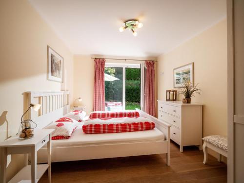 1 dormitorio con 1 cama con almohadas rojas y blancas en Alpensuiten en Ellmau