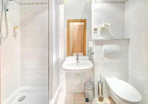 a bathroom with a sink and a toilet and a shower at Hotel FIS in Štrbské Pleso