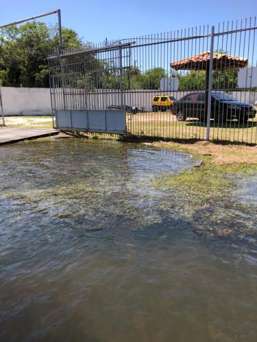 a pool of water next to a fence at Chalé em Barreirinhas - Porto dos Lençóis in Barreirinhas