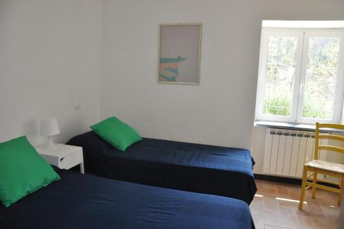 een slaapkamer met 2 bedden en een raam bij Rossola House in Bonassola