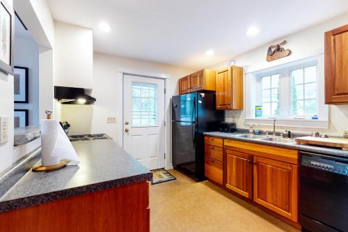 a kitchen with wooden cabinets and a black refrigerator at Harbor House in Camden