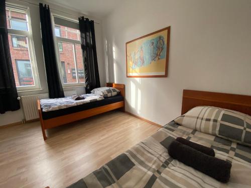 - une chambre avec 2 lits et 2 fenêtres dans l'établissement Apartment in guter Lage für bis zu 5 Personen, à Oldenbourg