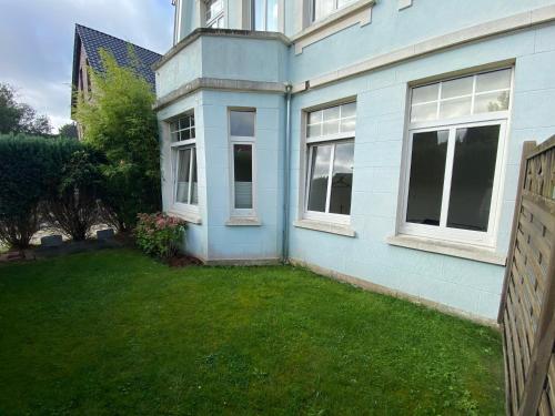 a blue house with a yard in front of it at Apartment in guter Lage für bis zu 5 Personen in Oldenburg