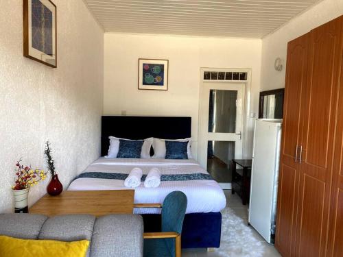een slaapkamer met een groot bed met blauwe kussens bij Pacho studio Apartment in Kisumu