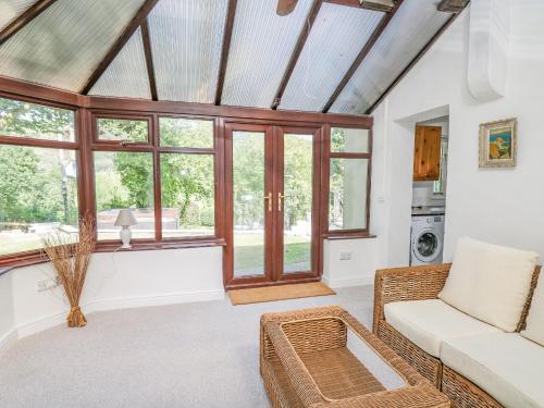 a living room with a couch and some windows at The Coach House at Plas Dolguog in Machynlleth