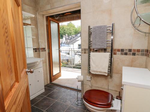 a bathroom with a toilet and a view of a balcony at The Coach House at Plas Dolguog in Machynlleth