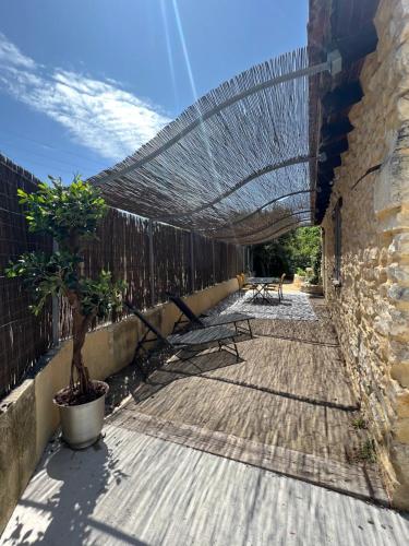 a patio with a fence and a table and benches at Cabanon provençal in Rochefort-du-Gard